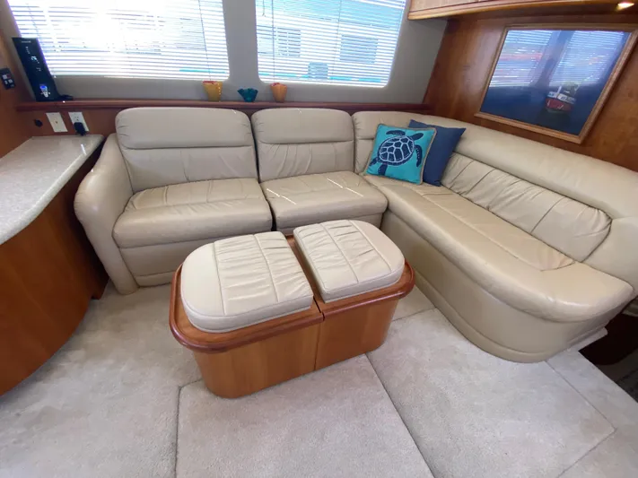 Aqua Holic Yacht Photos Pics Luxurious 2002 Silverton 43 MY yacht interior with beige leather seating and decorative pillows.