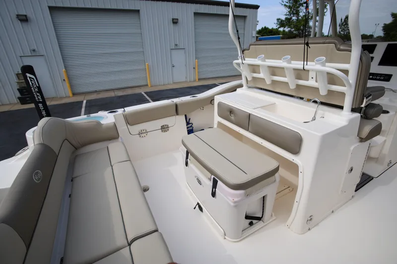  Yacht Photos Pics 2023 Key West 263 FS boat interior with seating and storage, docked near a warehouse.