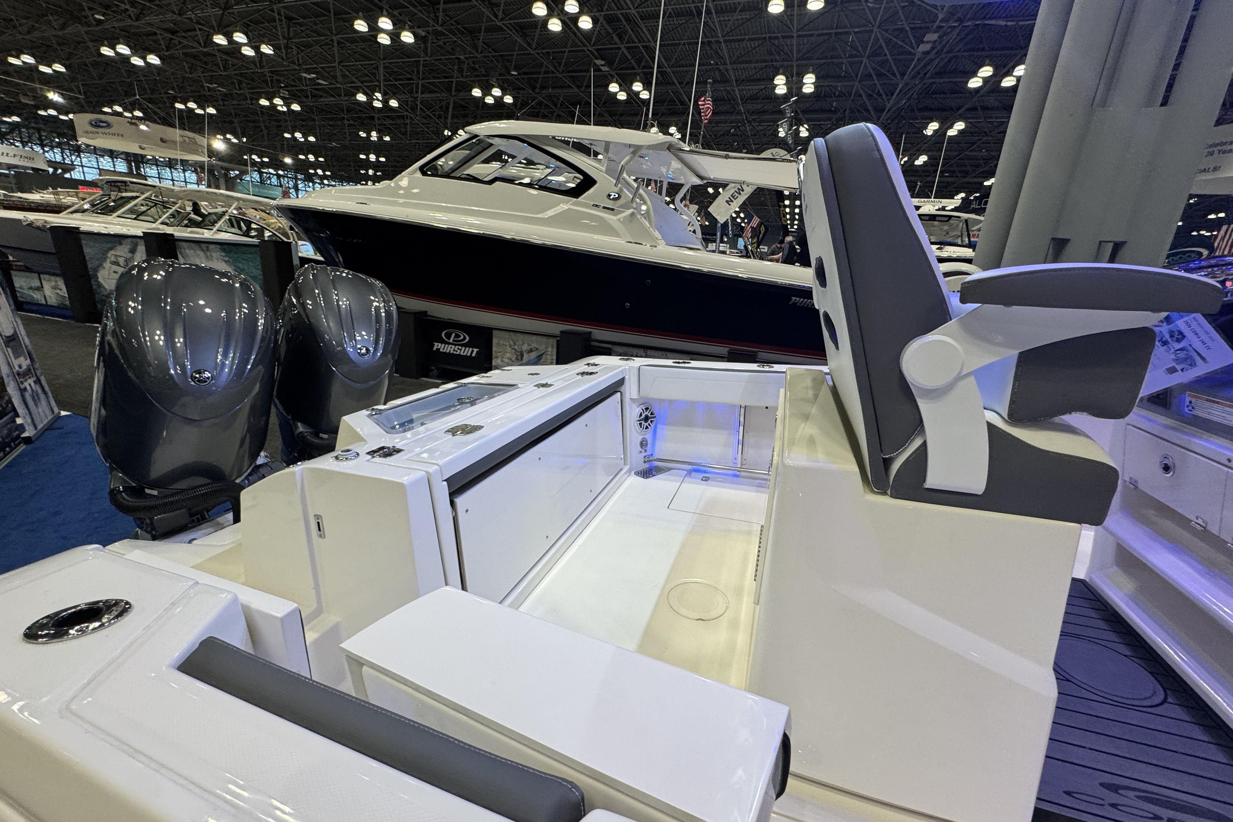 2026 Cobia 245 Center Console boat interior with dual engines at a boat show.