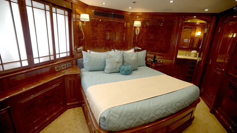 Homecoming Yacht Photos Pics Luxurious bedroom interior on 2010 Horizon 136 Premier yacht, featuring elegant wood paneling and plush bedding.