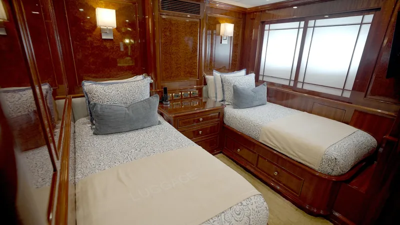Homecoming Yacht Photos Pics Luxurious twin bedroom on 2010 Horizon 136 Premier yacht, featuring elegant wood paneling.