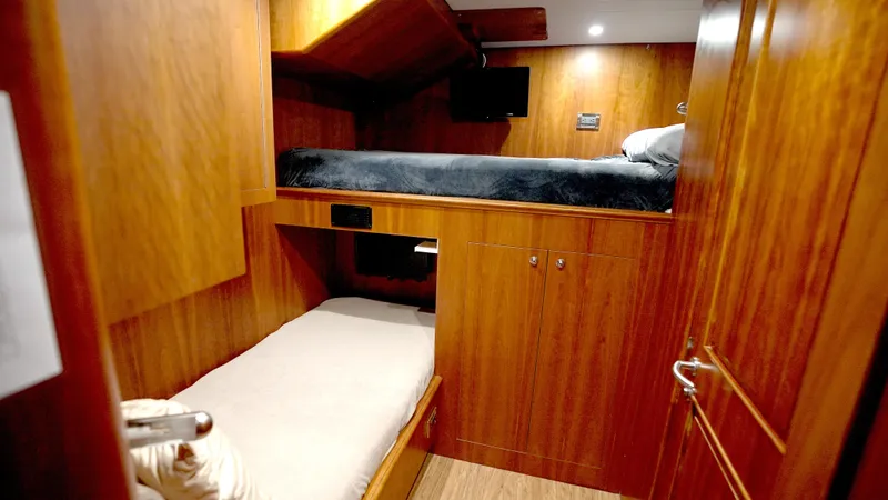 Homecoming Yacht Photos Pics Cozy wooden cabin interior with bunk beds on a 2010 Horizon 136 Premier yacht.