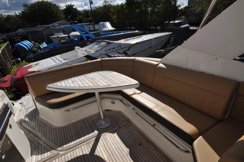  Yacht Photos Pics 2020 Sea Ray Sundancer 320 yacht with tan seating and wooden deck, docked outdoors.