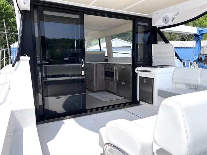  Yacht Photos Pics 2022 Regal 42 Grande Coupe yacht interior with sliding glass doors and modern kitchen.