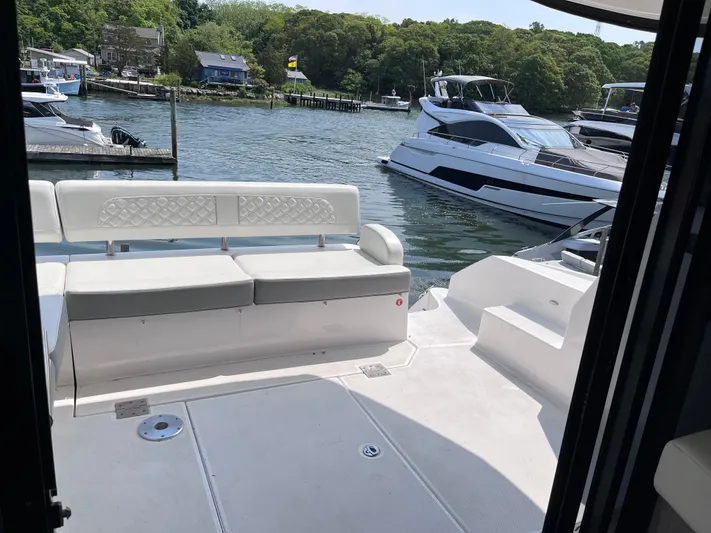  Yacht Photos Pics 2022 Regal 42 Grande Coupe yacht with white seating at a marina.