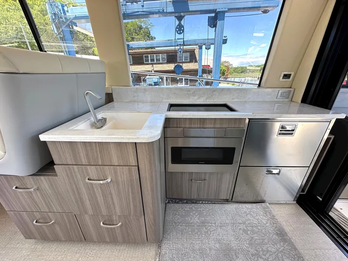  Yacht Photos Pics Modern kitchen area in 2022 Regal 42 Grande Coupe yacht with sink, stove, and storage.