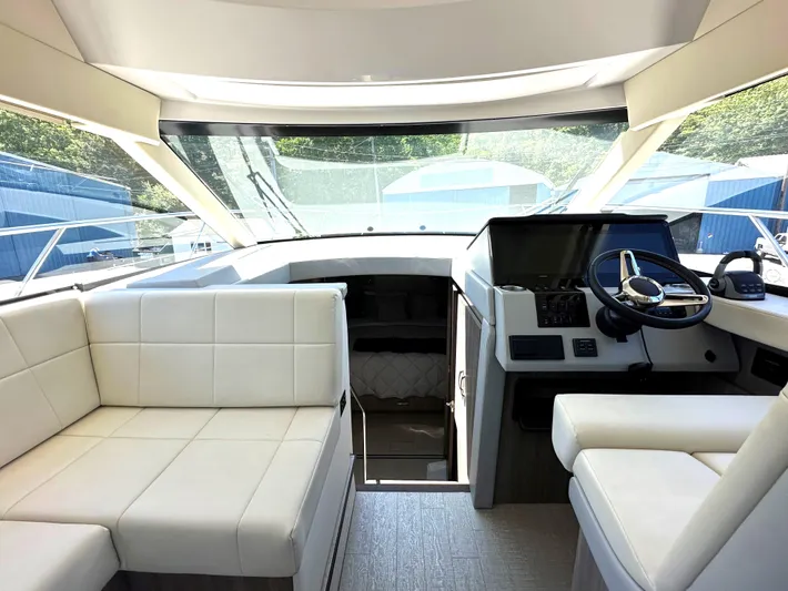 Yacht Photos Pics Interior of 2022 Regal 42 Grande Coupe yacht with white leather seating and modern helm.
