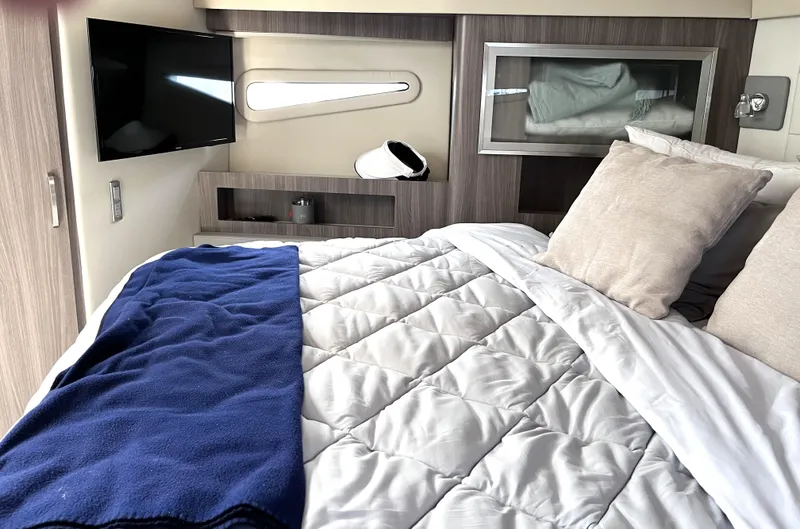  Yacht Photos Pics Luxurious bedroom interior of 2022 Regal 42 Grande Coupe yacht with TV and modern decor.