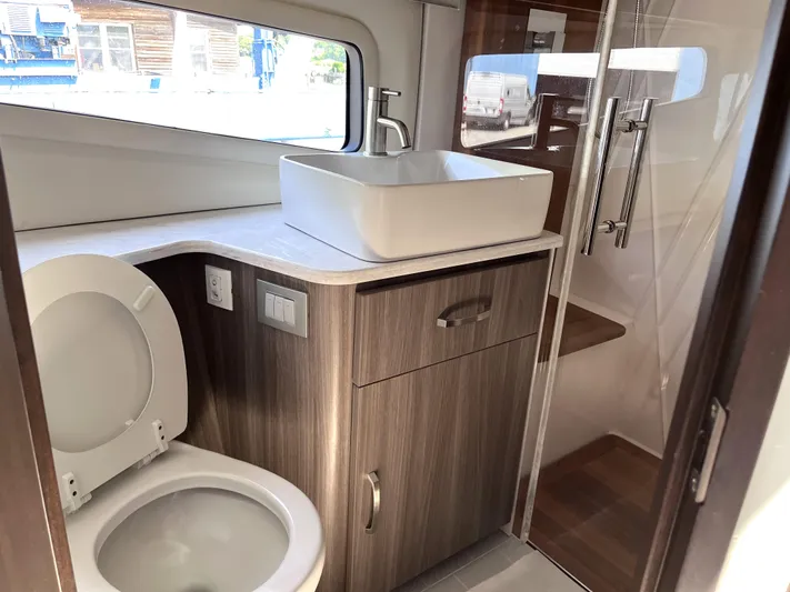  Yacht Photos Pics 2022 Regal 42 Grande Coupe bathroom with modern sink, toilet, and glass shower.