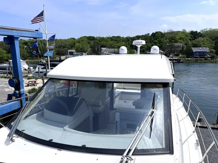  Yacht Photos Pics 2022 Regal 42 Grande Coupe yacht docked at a marina with flags in the background.