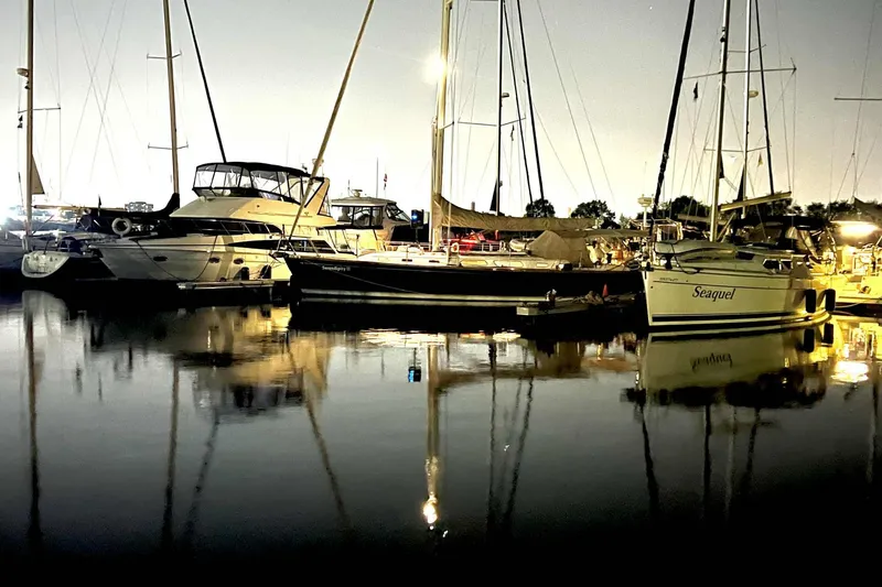 Serendipity II Yacht Photos Pics Boats docked at night, reflecting on calm water, featuring a 1999 Sabre 452.