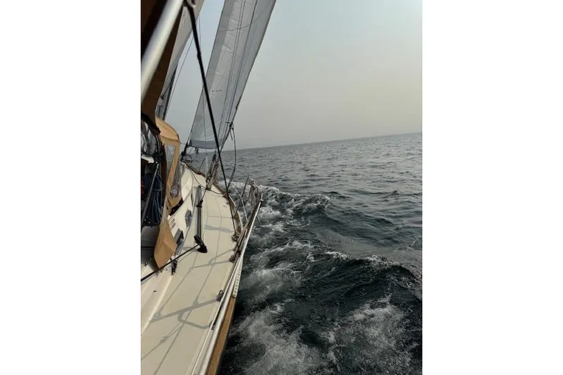 Serendipity II Yacht Photos Pics Sailing on a 1999 Sabre 452 yacht, cutting through ocean waves under a clear sky.