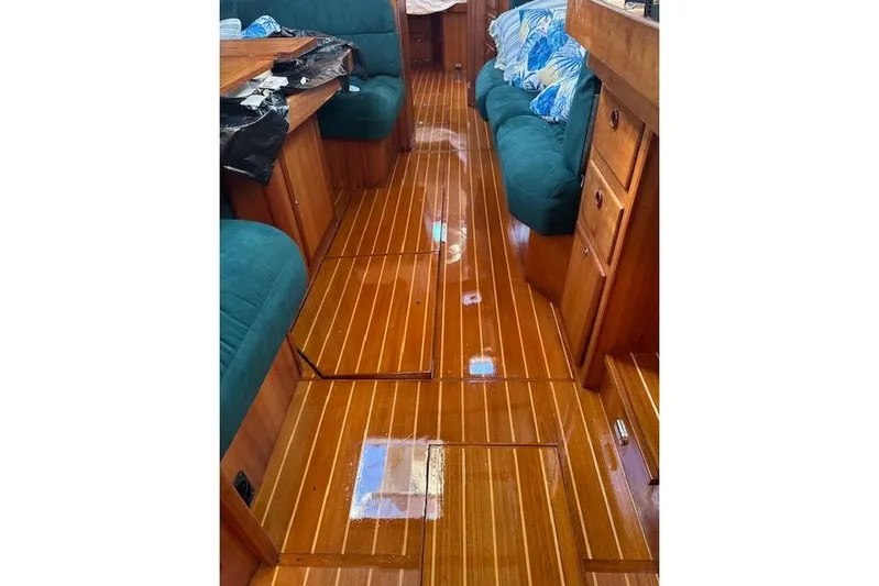 Serendipity II Yacht Photos Pics Interior of a 1999 Sabre 452 yacht with polished wooden flooring and teal seating.