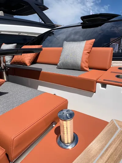  Yacht Photos Pics Luxury seating on 2025 Astondoa 677 Coupe yacht with orange and gray cushions.