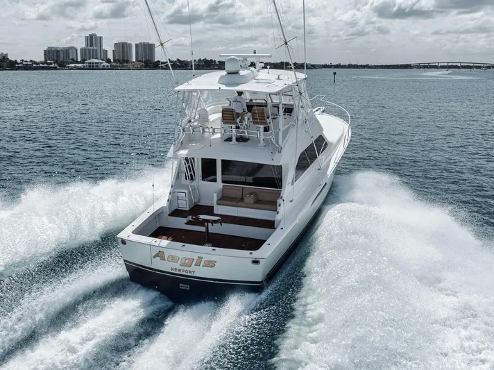 Aegis Yacht Photos Pics 2009 Viking 54 Convertible yacht cruising on open water, city skyline in background.