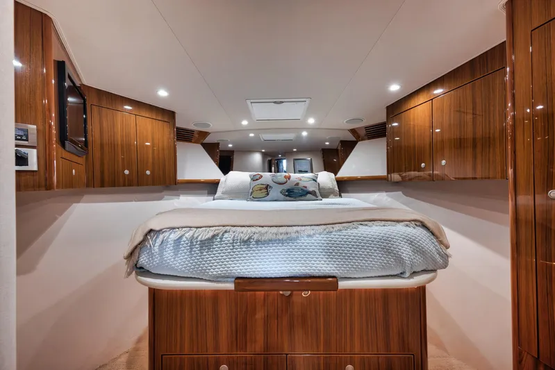Aegis Yacht Photos Pics Luxurious bedroom interior of 2009 Viking 54 Convertible yacht with wood paneling.