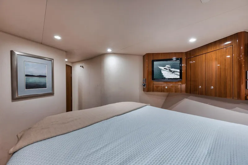 Aegis Yacht Photos Pics Luxurious bedroom interior of 2009 Viking 54 Convertible yacht with TV and artwork.