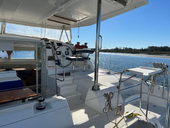 Sunbear Yacht Photos Pics 2008 Lagoon 420 yacht interior with steering wheel, overlooking serene water and shoreline.