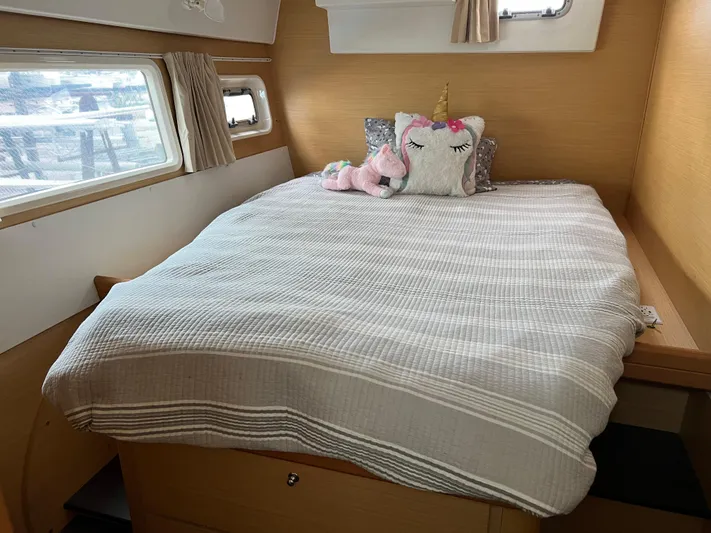 Sunbear Yacht Photos Pics Cozy bedroom in 2008 Lagoon 420 yacht with unicorn-themed decor and large windows.