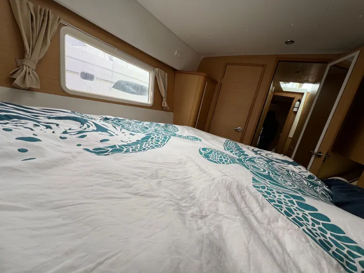 Sunbear Yacht Photos Pics Interior cabin of 2008 Lagoon 420 yacht with patterned bedding and window view.