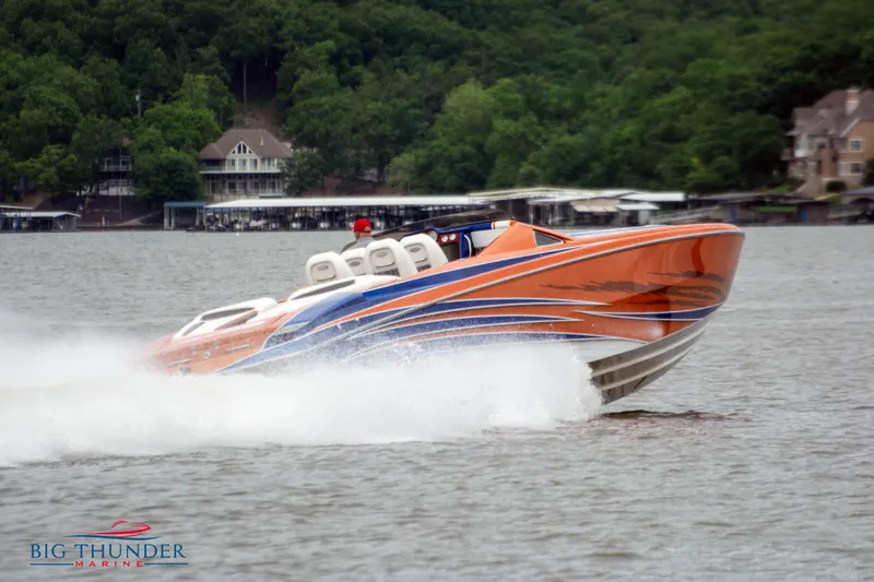  Yacht Photos Pics 2015 Nor-Tech 527 Super Vee speedboat on a lake, surrounded by lush greenery.