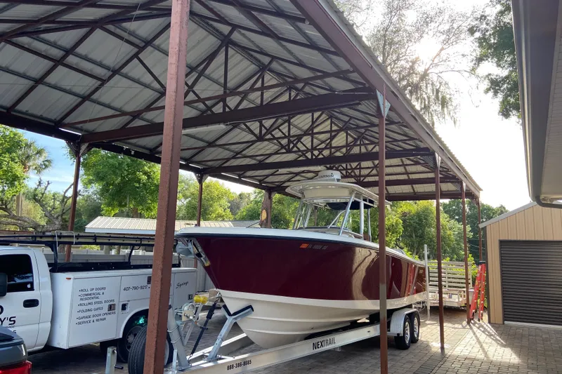  Yacht Photos Pics 2010 Pursuit C 280 Center Console boat on trailer under metal canopy.