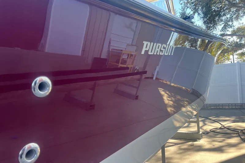  Yacht Photos Pics 2010 Pursuit C 280 Center Console boat with reflective hull in outdoor setting.