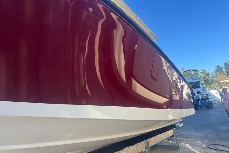  Yacht Photos Pics 2010 Pursuit C 280 Center Console boat with glossy red hull in a marina setting.