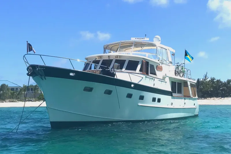 El Sueno Yacht Photos Pics Grand Alaskan 60 Pilothouse yacht, 1998 model, anchored near a tropical beach.