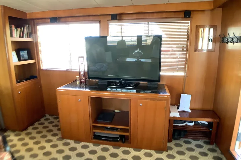 El Sueno Yacht Photos Pics Interior of 1998 Grand Alaskan 60 Pilothouse with TV, wooden cabinetry, and patterned flooring.