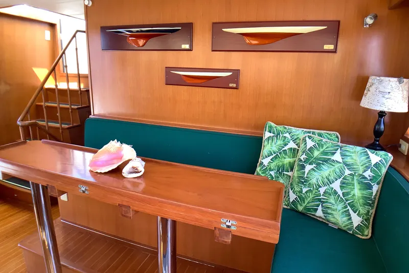 El Sueno Yacht Photos Pics Interior of 1998 Grand Alaskan 60 Pilothouse with wooden decor and green seating.