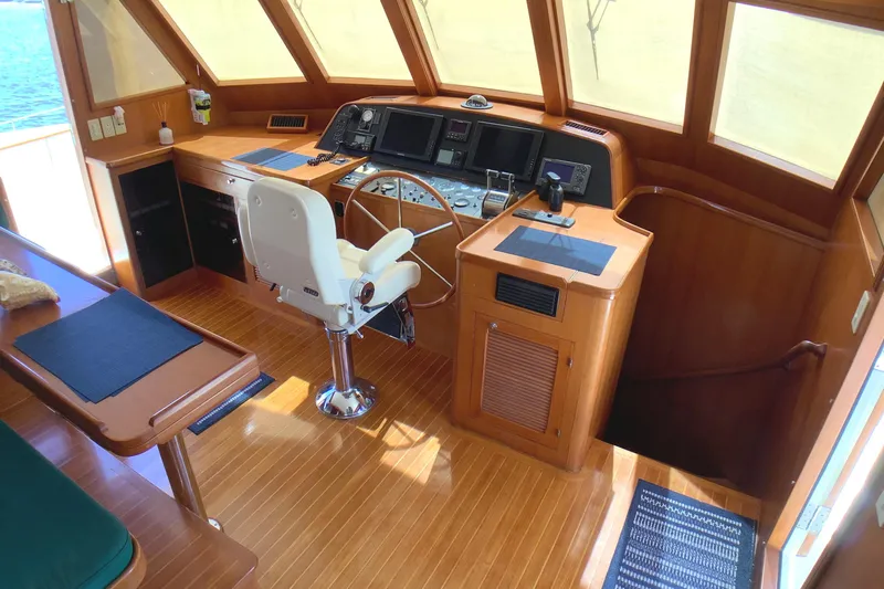 El Sueno Yacht Photos Pics Pilothouse interior of 1998 Grand Alaskan 60, featuring helm station and wooden flooring.