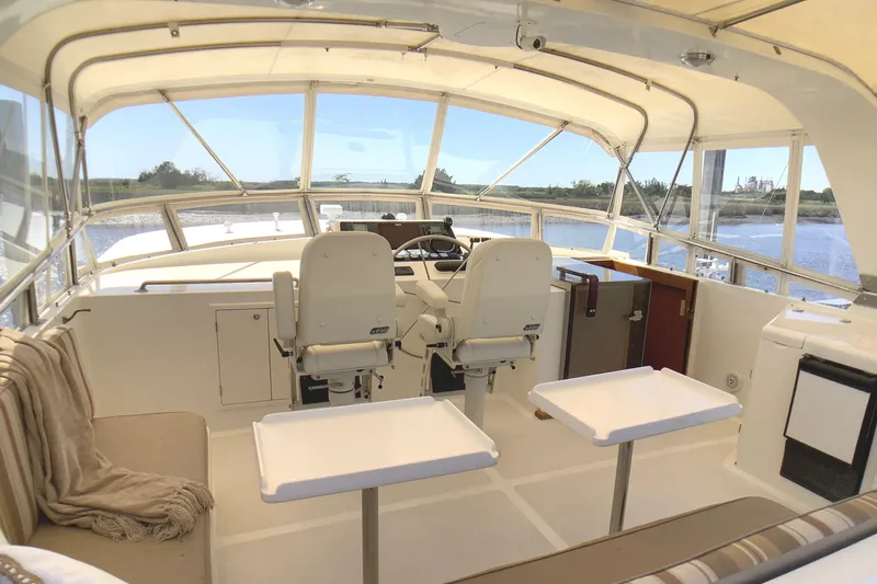 El Sueno Yacht Photos Pics Luxurious 1998 Grand Alaskan 60 Pilothouse interior with seating and helm, overlooking serene waters.