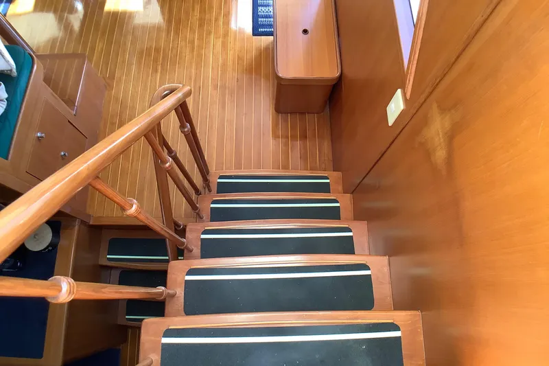 El Sueno Yacht Photos Pics Wooden staircase inside 1998 Grand Alaskan 60 Pilothouse yacht, featuring non-slip treads.