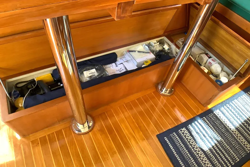 El Sueno Yacht Photos Pics Storage compartment on 1998 Grand Alaskan 60 Pilothouse with wooden flooring and metal supports.