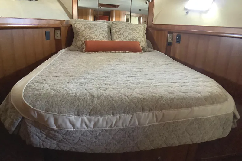 El Sueno Yacht Photos Pics Luxurious bedroom interior of 1998 Grand Alaskan 60 Pilothouse yacht with elegant bedding.
