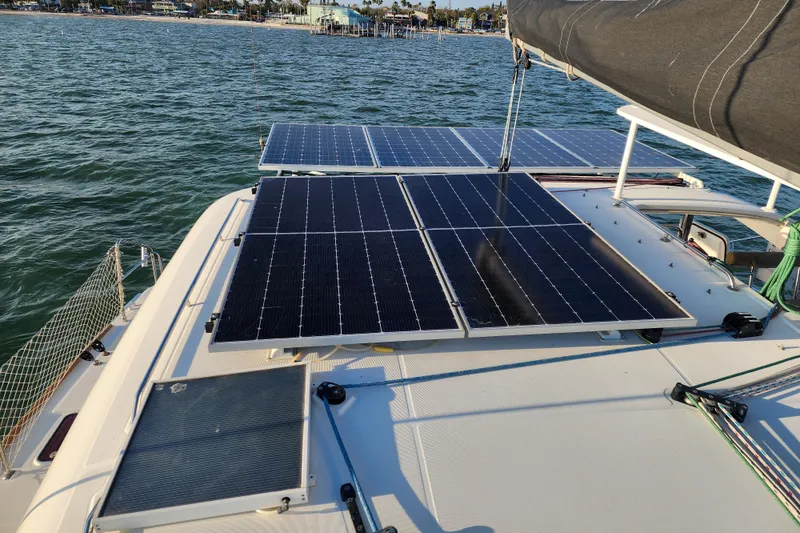 Dao And Out Yacht Photos Pics 2011 Lagoon 400 catamaran with solar panels on deck, sailing near coastline.