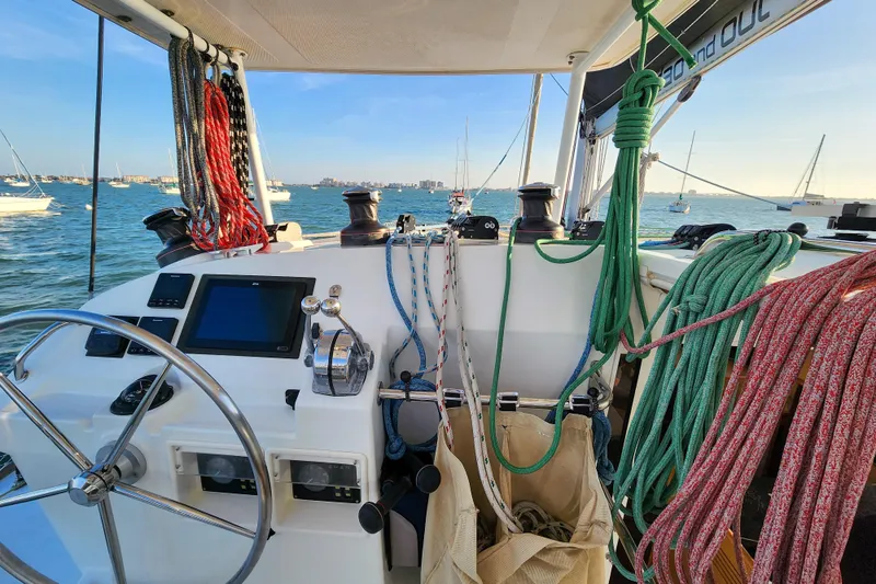 Dao And Out Yacht Photos Pics Cockpit of 2011 Lagoon 400 catamaran with ropes and steering wheel, sailing on calm waters.