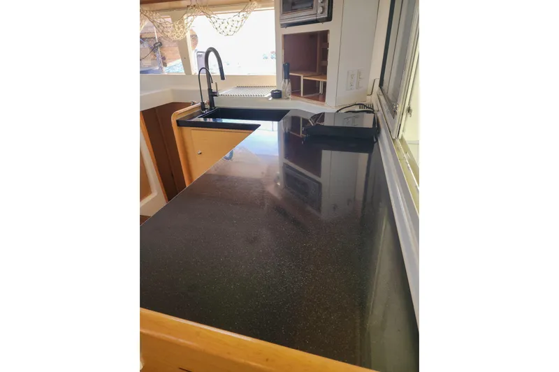 Dao And Out Yacht Photos Pics Modern kitchen interior of 2011 Lagoon 400 catamaran with sleek black countertop.