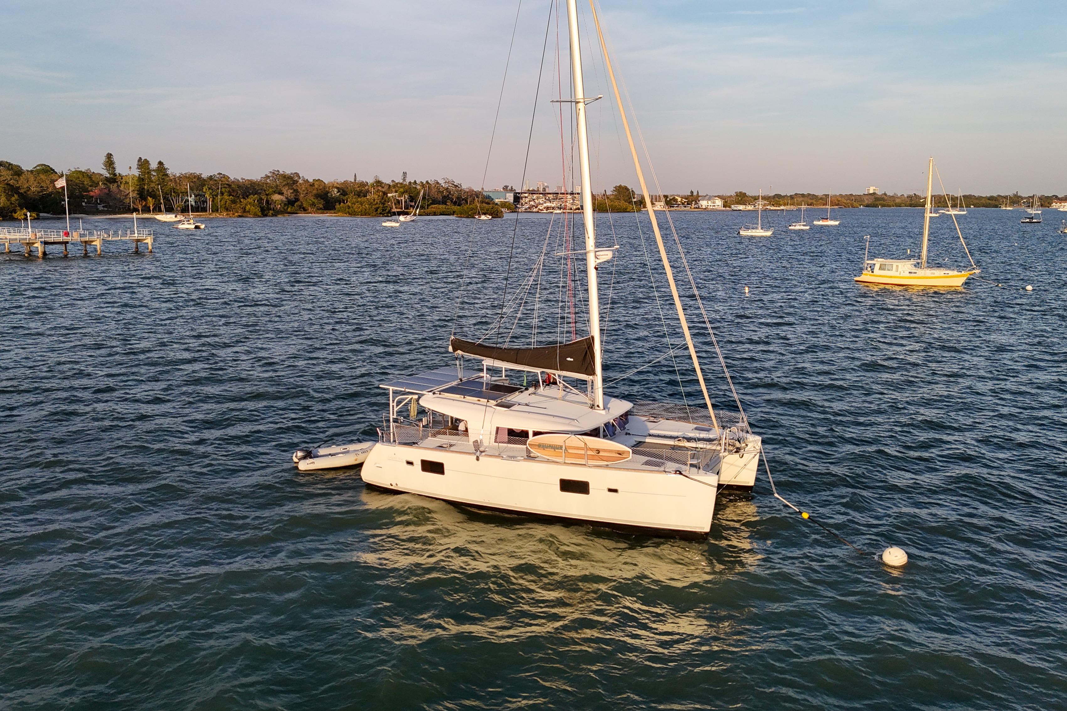 2011 Lagoon 400 catamaran anchored in a scenic bay with other boats.