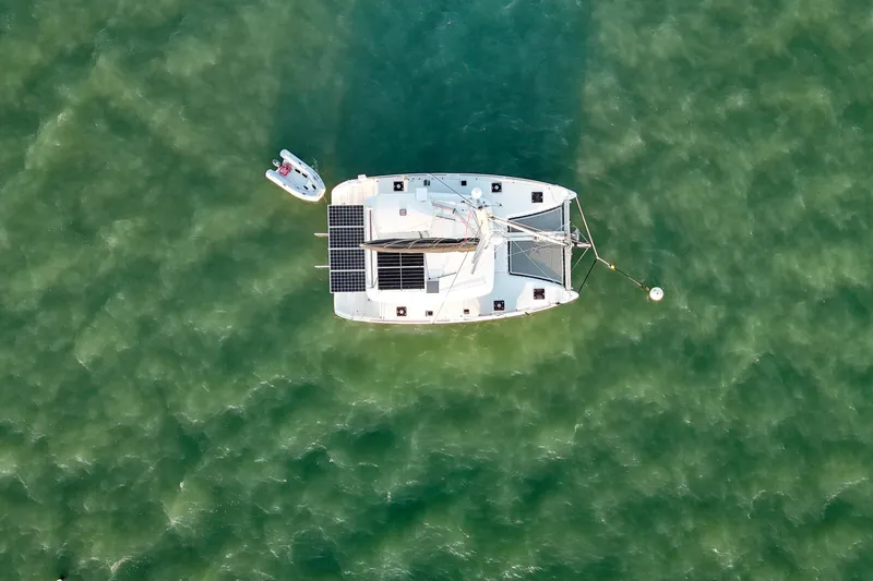 Dao And Out Yacht Photos Pics Aerial view of 2011 Lagoon 400 catamaran with solar panels on green water.