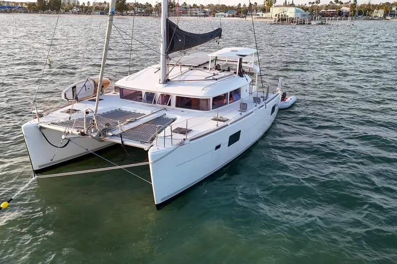 Dao And Out Yacht Photos Pics 2011 Lagoon 400 catamaran sailing on calm waters near a coastal town.