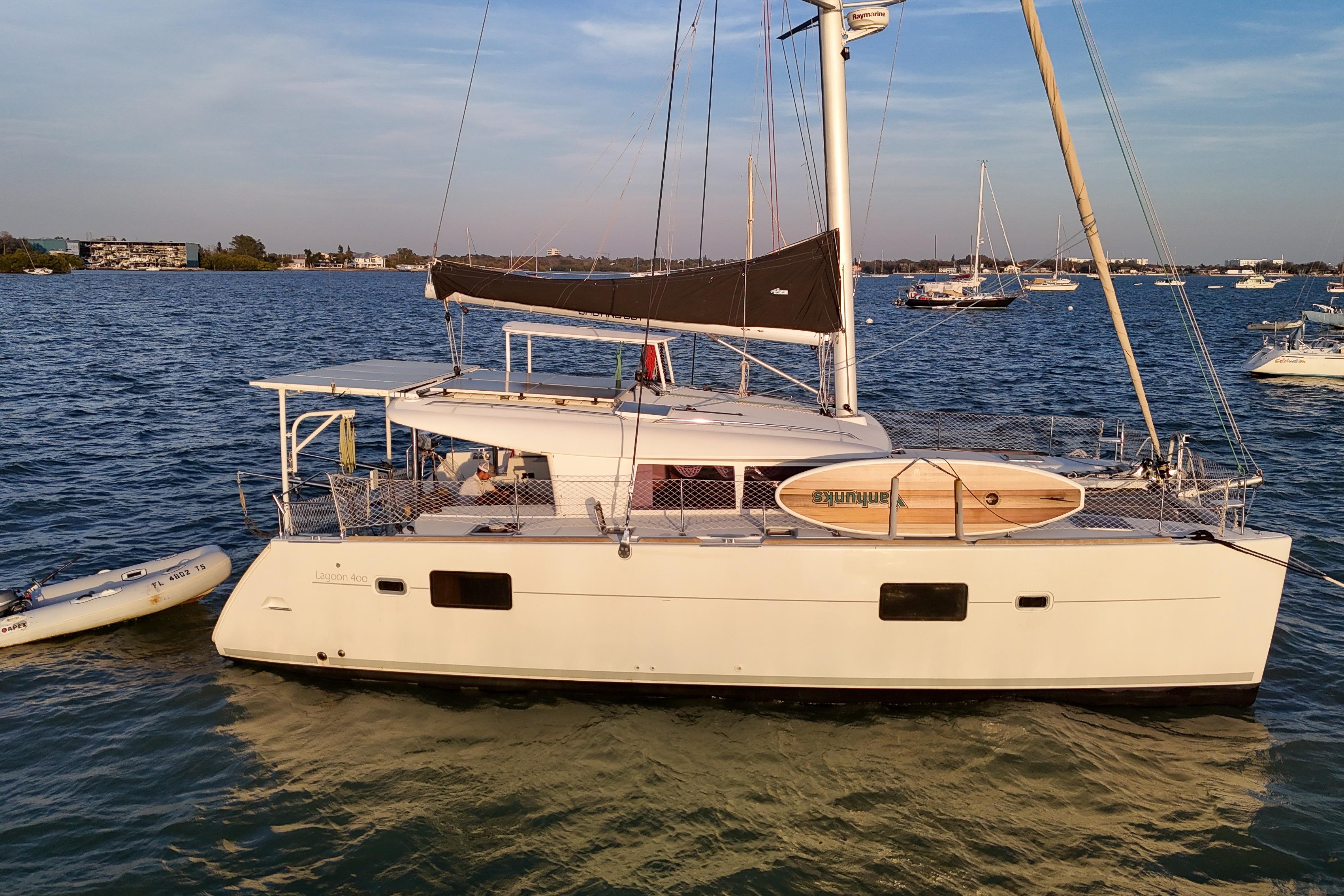 2011 Lagoon 400 catamaran anchored in calm waters with a paddleboard on deck.