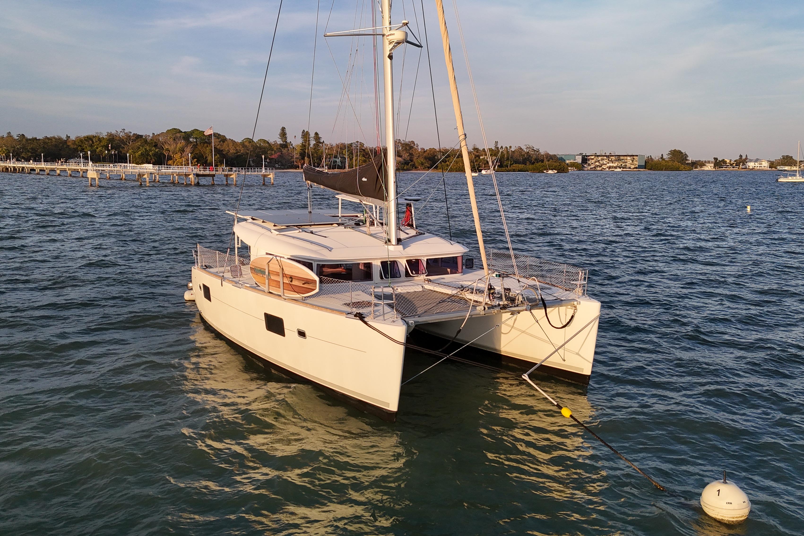 2011 Lagoon 400 catamaran anchored on calm waters near a scenic shoreline.