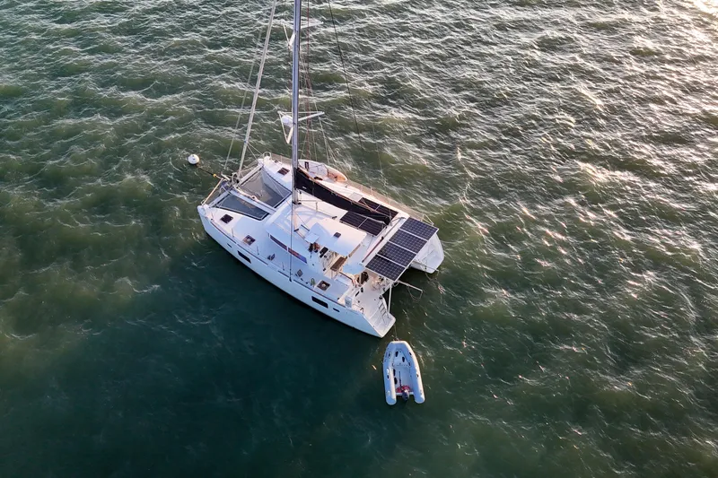 Dao And Out Yacht Photos Pics Aerial view of 2011 Lagoon 400 catamaran with solar panels on ocean.