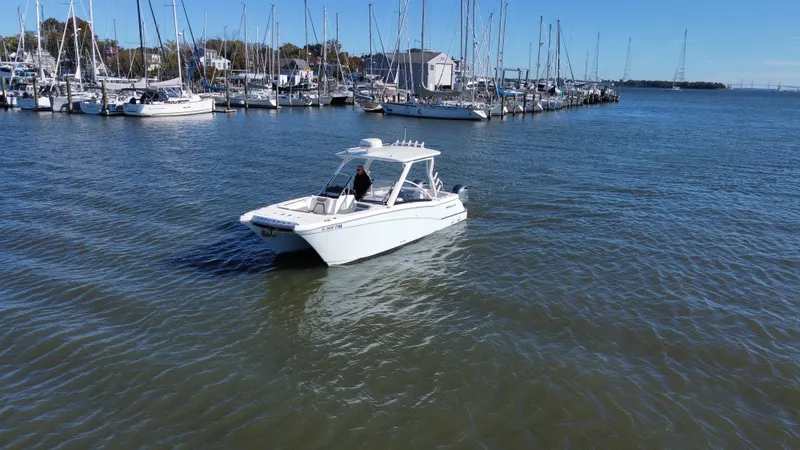 Reel'y Busy Yacht Photos Pics 2020 World Cat 280 DC x boat cruising near marina with sailboats.