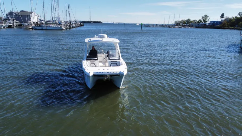 Reel'y Busy Yacht Photos Pics 2020 World Cat 280 DC x boat cruising in a marina with sailboats.