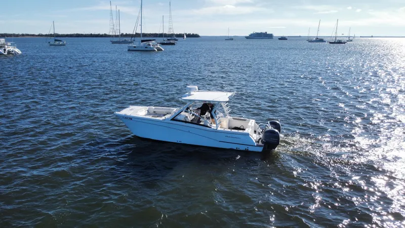 Reel'y Busy Yacht Photos Pics 2020 World Cat 280 DC x cruising on a sunny, calm sea with other boats nearby.