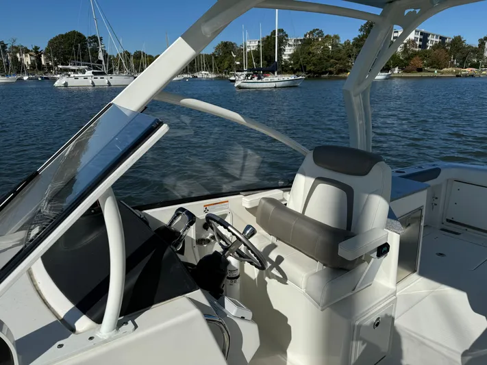 Reel'y Busy Yacht Photos Pics 2020 World Cat 280 DC x boat interior with steering wheel and seating, docked on a sunny day.