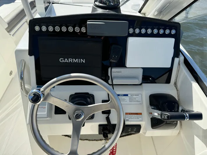 Reel'y Busy Yacht Photos Pics 2020 World Cat 280 DC x boat dashboard with Garmin navigation system and steering wheel.
